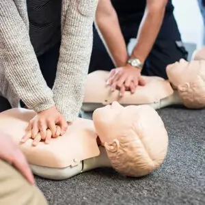 People practicing CPR on training mannequins.